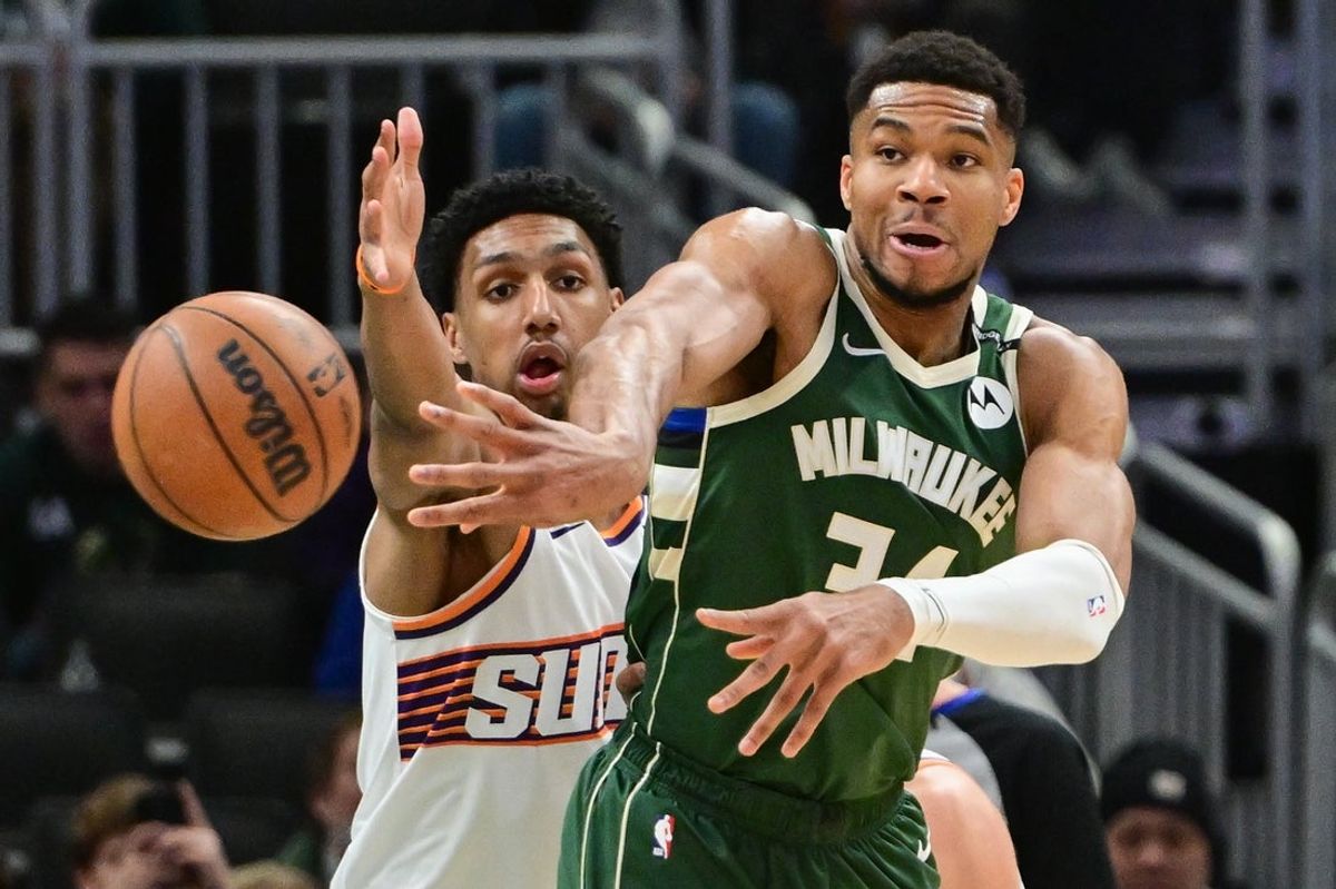 Apr 1, 2025; Milwaukee, Wisconsin, USA;  Milwaukee Bucks forward Giannis Antetokounmpo (34) passes the ball away from Phoenix Suns guard Ryan Dunn (0) in the first quarter at Fiserv Forum. Mandatory Credit: Benny Sieu-Imagn Images