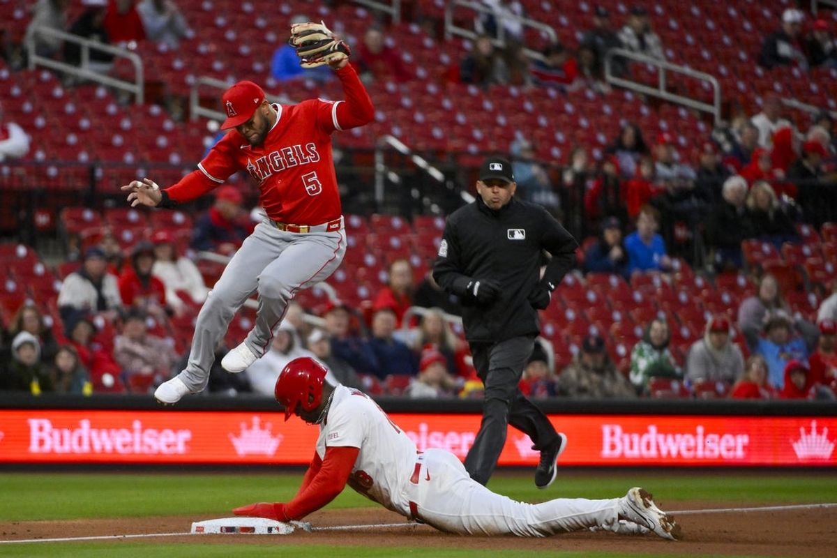 Apr 1, 2025; St. Louis, Missouri, USA;  Los Angeles Angels third baseman Yoan Moncada (5) leaps over St. Louis Cardinals right fielder Jordan Walker (18) as he steals third base during the second inning at Busch Stadium. Mandatory Credit: Jeff Curry-Imagn Images