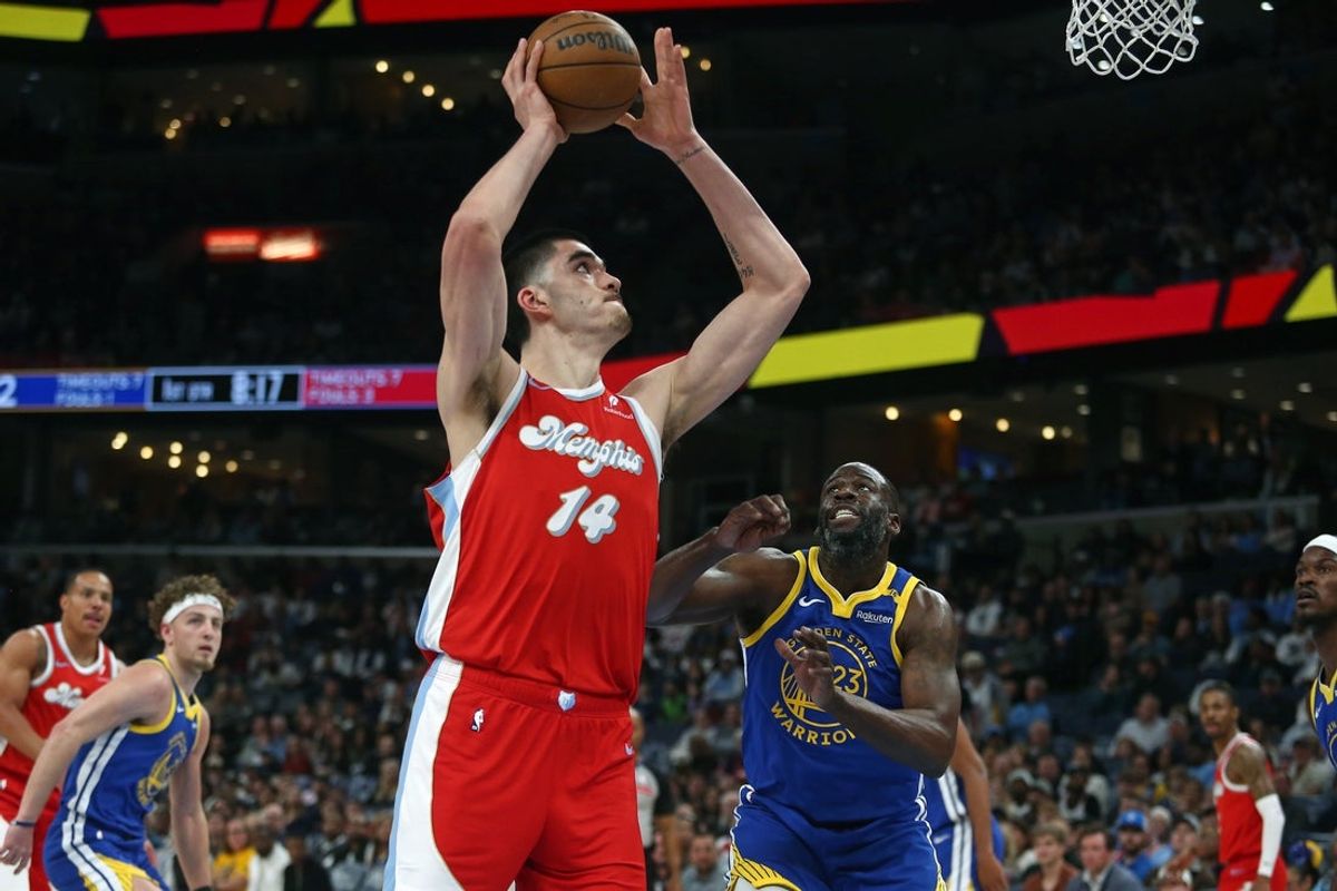 Apr 1, 2025; Memphis, Tennessee, USA; Memphis Grizzlies center Zach Edey (14) shoots as Golden State Warriors forward Draymond Green (23) defends during the first quarter at FedExForum. Mandatory Credit: Petre Thomas-Imagn Images
