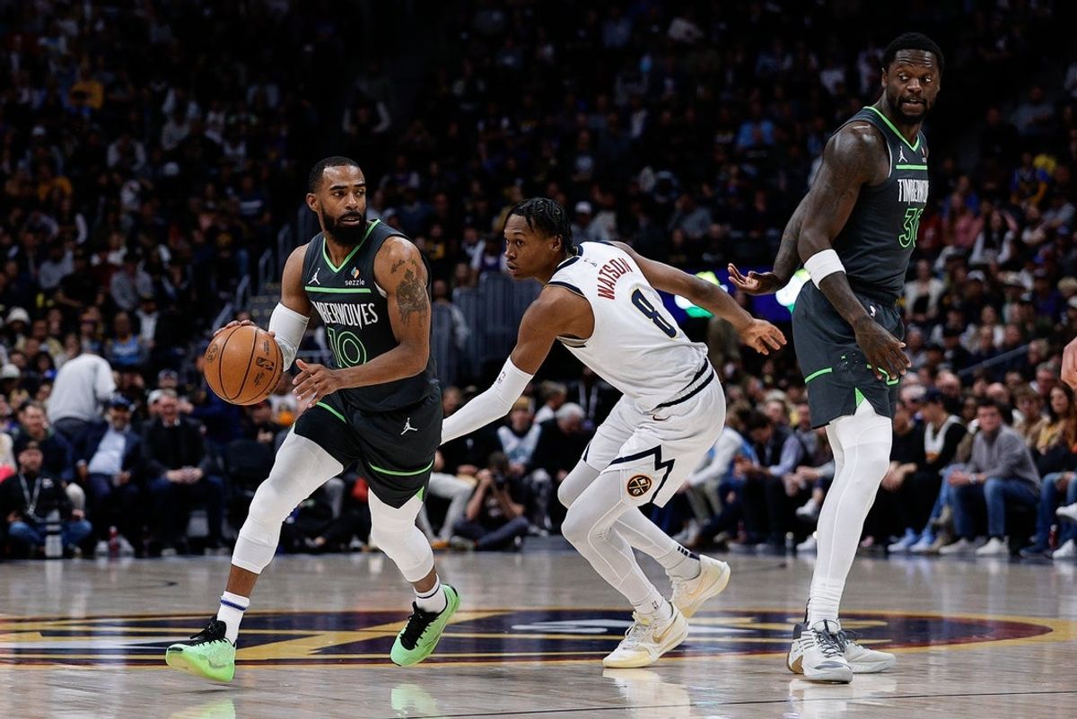 Apr 1, 2025; Denver, Colorado, USA; Minnesota Timberwolves guard Mike Conley (10) controls the ball against Denver Nuggets forward Peyton Watson (8) as forward Julius Randle (30) defends in the first quarter at Ball Arena. Mandatory Credit: Isaiah J. Downing-Imagn Images