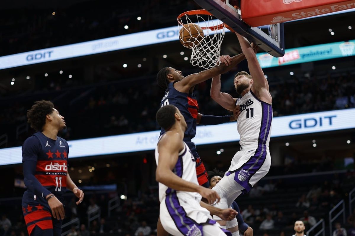 Apr 2, 2025; Washington, District of Columbia, USA; Sacramento Kings forward Domantas Sabonis (11) dunks th ball as Washington Wizards forward Alex Sarr (20) defends in the first half at Capital One Arena. Mandatory Credit: Geoff Burke-Imagn Images