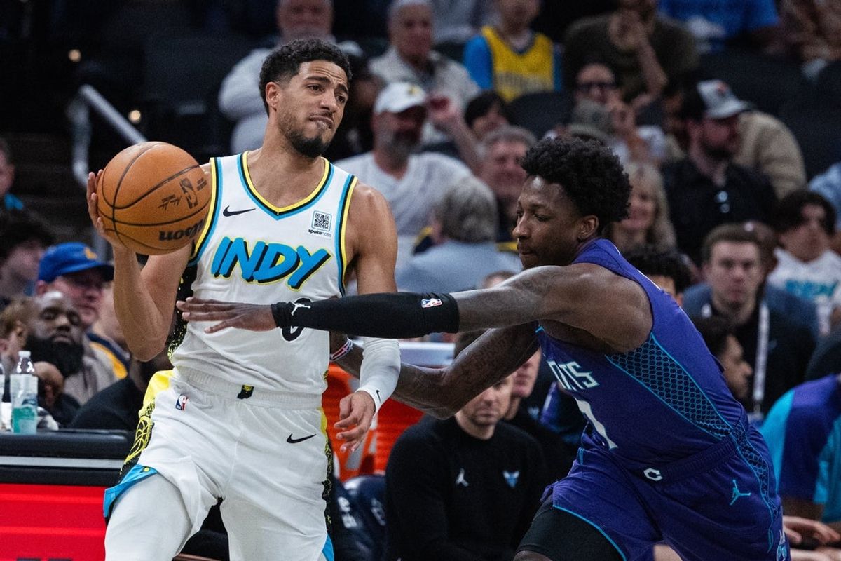 Apr 2, 2025; Indianapolis, Indiana, USA; Indiana Pacers guard Tyrese Haliburton (0) passes the ball while Charlotte Hornets guard Damion Baugh (7) defends in the first half at Gainbridge Fieldhouse. Mandatory Credit: Trevor Ruszkowski-Imagn Images