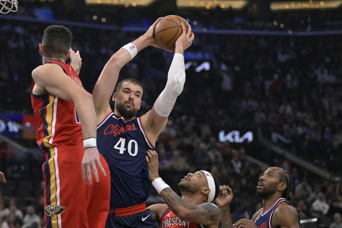 Apr 2, 2025; Inglewood, California, USA;  Los Angeles Clippers center Ivica Zubac (40) brings down a rebound in between New Orleans Pelicans center Karlo Matkovic (17) and forward Bruce Brown (00) in the first half at Intuit Dome. Mandatory Credit: Jayne Kamin-Oncea-Imagn Images