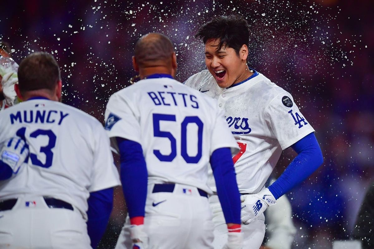 Apr 2, 2025; Los Angeles, California, USA; Los Angeles Dodgers designated hitter Shohei Ohtani (17) is greeted at home after hitting a walk off solo home run against the Atlanta Braves during the ninth inning at Dodger Stadium. Mandatory Credit: Gary A. Vasquez-Imagn Images