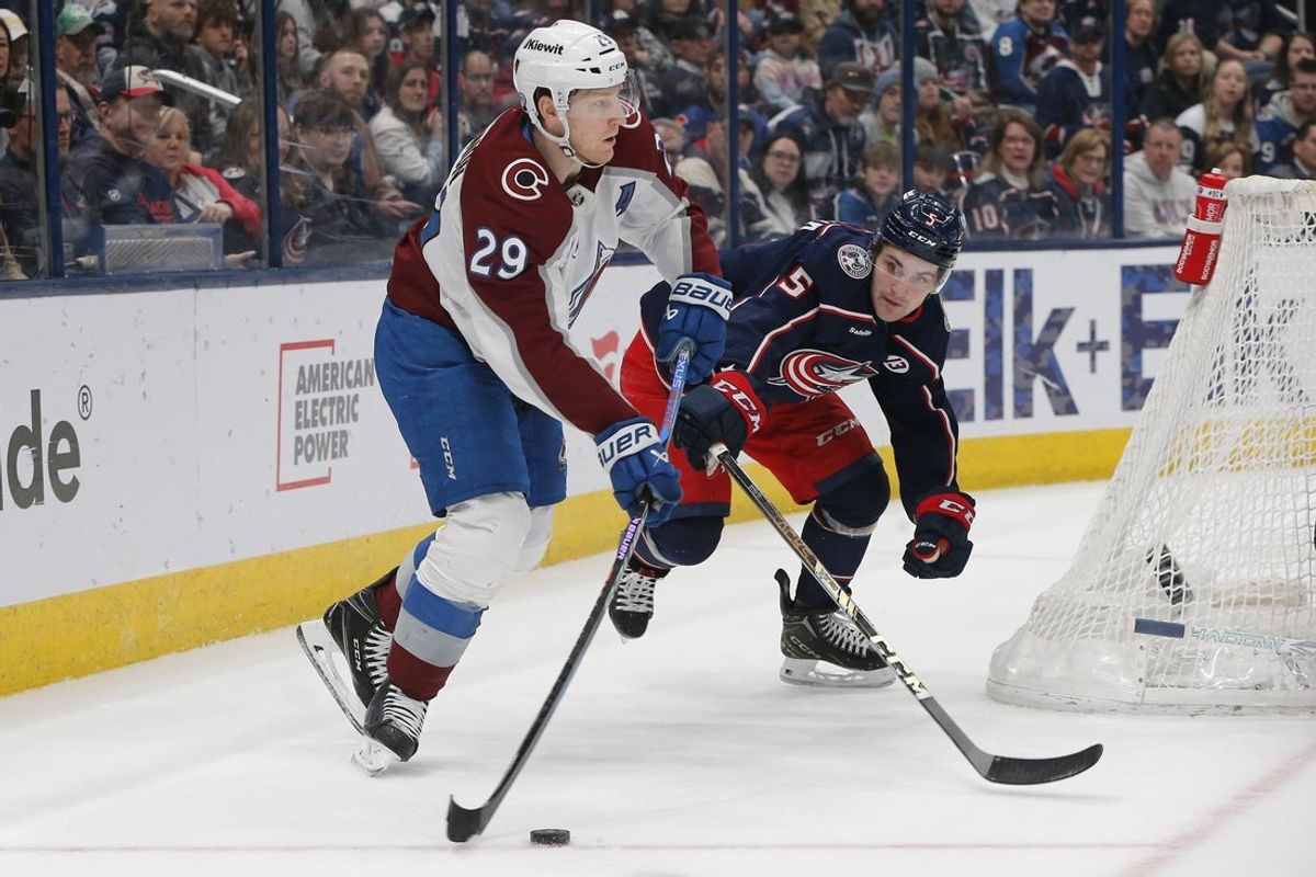 Apr 3, 2025; Columbus, Ohio, USA; Colorado Avalanche center Nathan MacKinnon (29) passes the puck as Columbus Blue Jackets defenseman Denton Mateychuk (5) trails the play during the first period at Nationwide Arena. Mandatory Credit: Russell LaBounty-Imagn Images