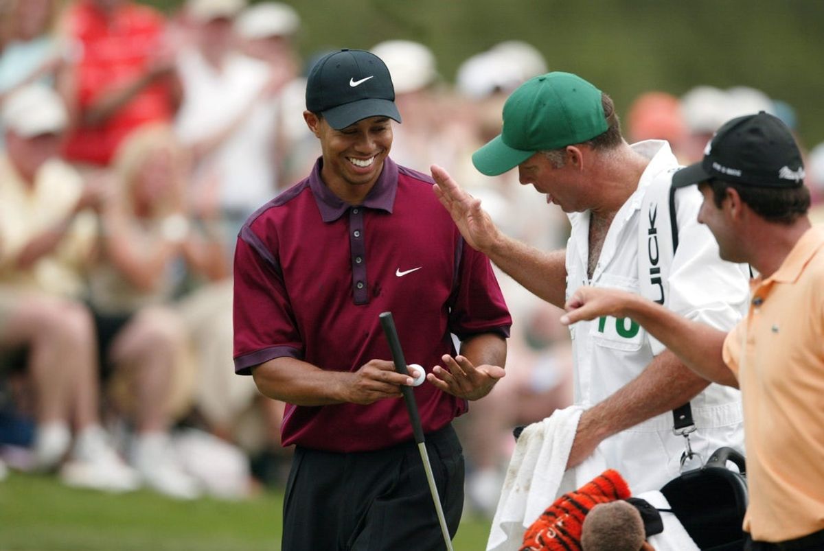 Three-time Masters Champion Tiger Woods gets a high five from his caddy Steve Williams as two-time Champion Jose Maria Olazabal also congratulates Tiger for the birdie on the 14th hole on the final day of the 2004 Masters Tournament at the Augusta National Golf Club, in Augusta, Ga.