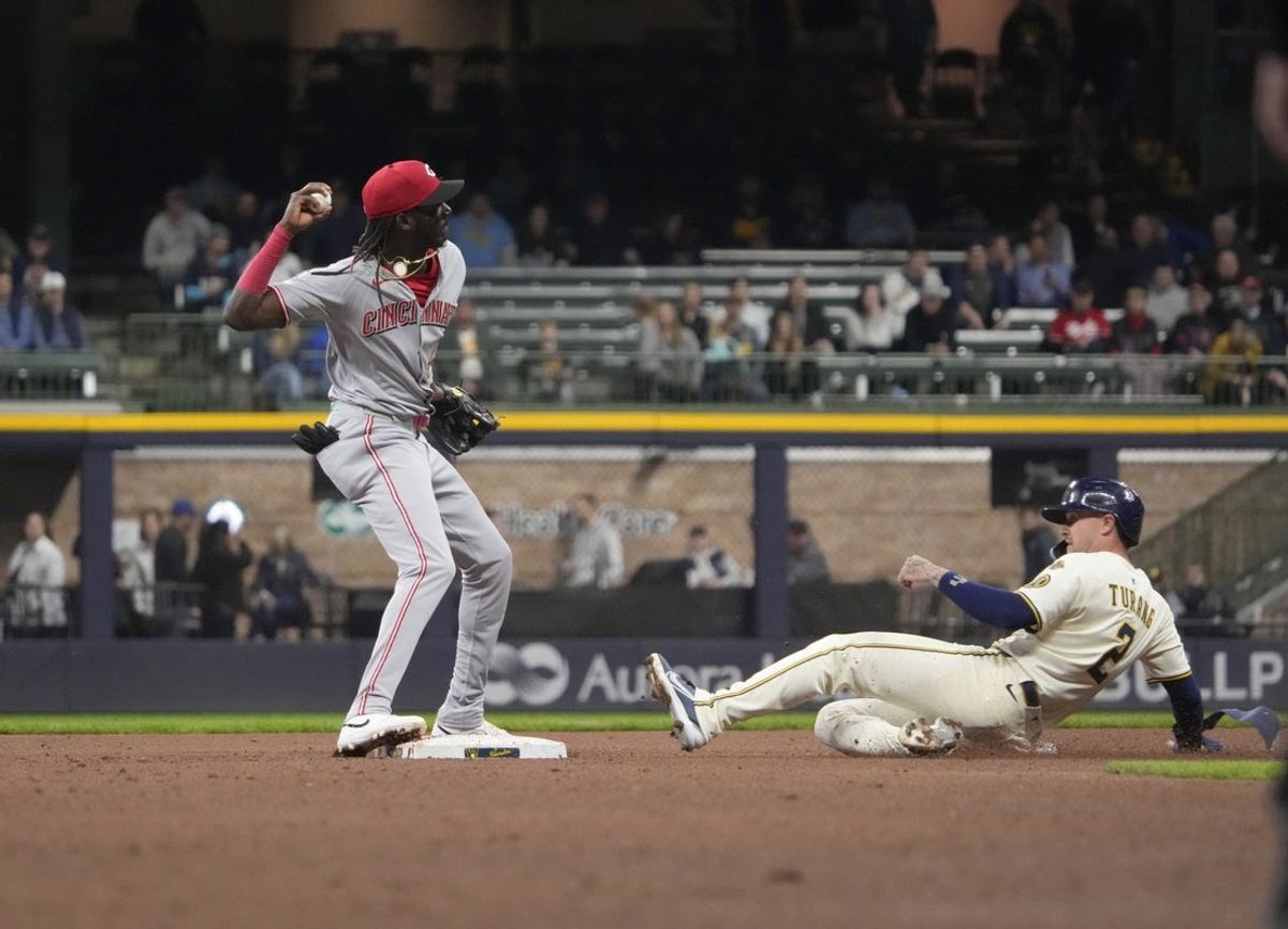 Apr 3, 2025; Milwaukee, Wisconsin, USA; Cincinnati Reds shortstop Elly De La Cruz (44) throws the ball to first base as he forces out Milwaukee Brewers second baseman Brice Turang (2) and completes the double play at American Family Field. Mandatory Credit: Michael McLoone-Imagn Images