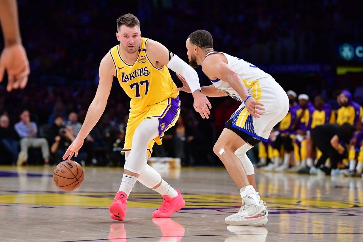 Apr 3, 2025; Los Angeles, California, USA; Los Angeles Lakers guard Luka Doncic (77) moves the ball against Golden State Warriors guard Stephen Curry (30) during the first half at Crypto.com Arena. Mandatory Credit: Gary A. Vasquez-Imagn Images