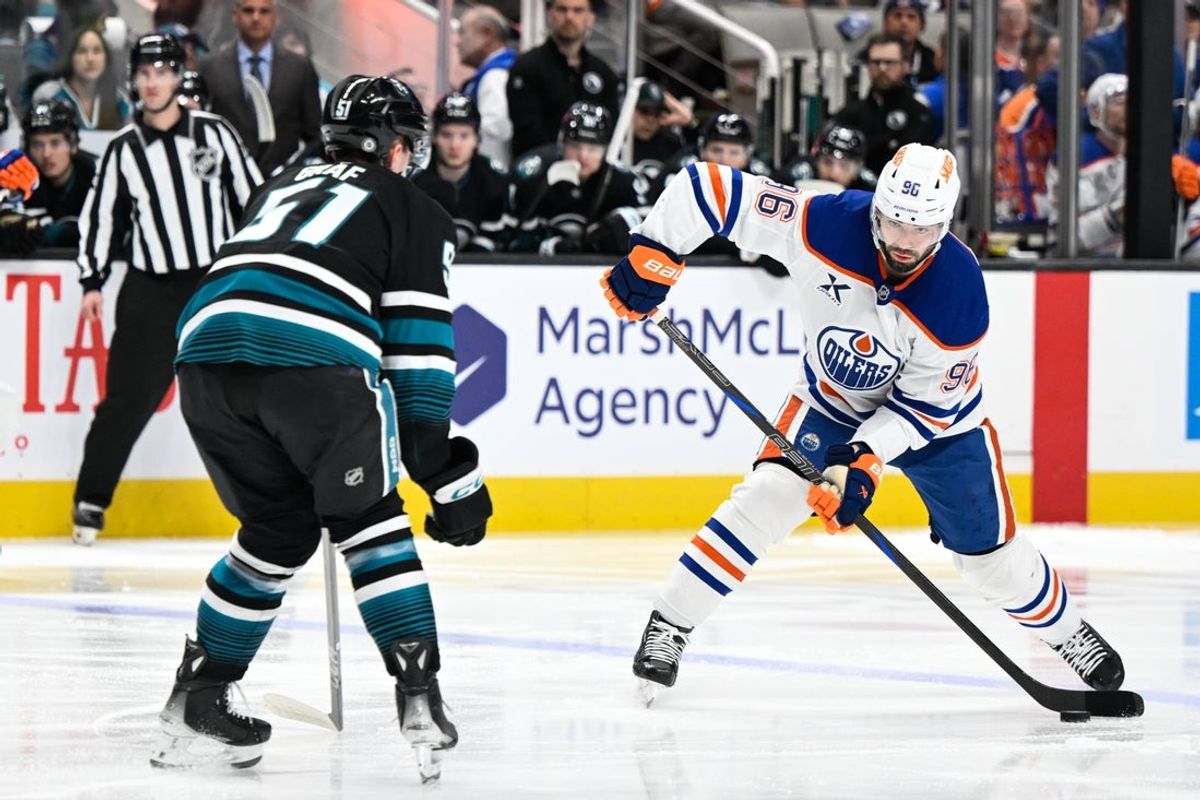 Apr 3, 2025; San Jose, California, USA; Edmonton Oilers defenseman Jake Walman (96) controls the puck against San Jose Sharks right wing Collin Graf (51) in the first period at SAP Center at San Jose. Mandatory Credit: Eakin Howard-Imagn Images
