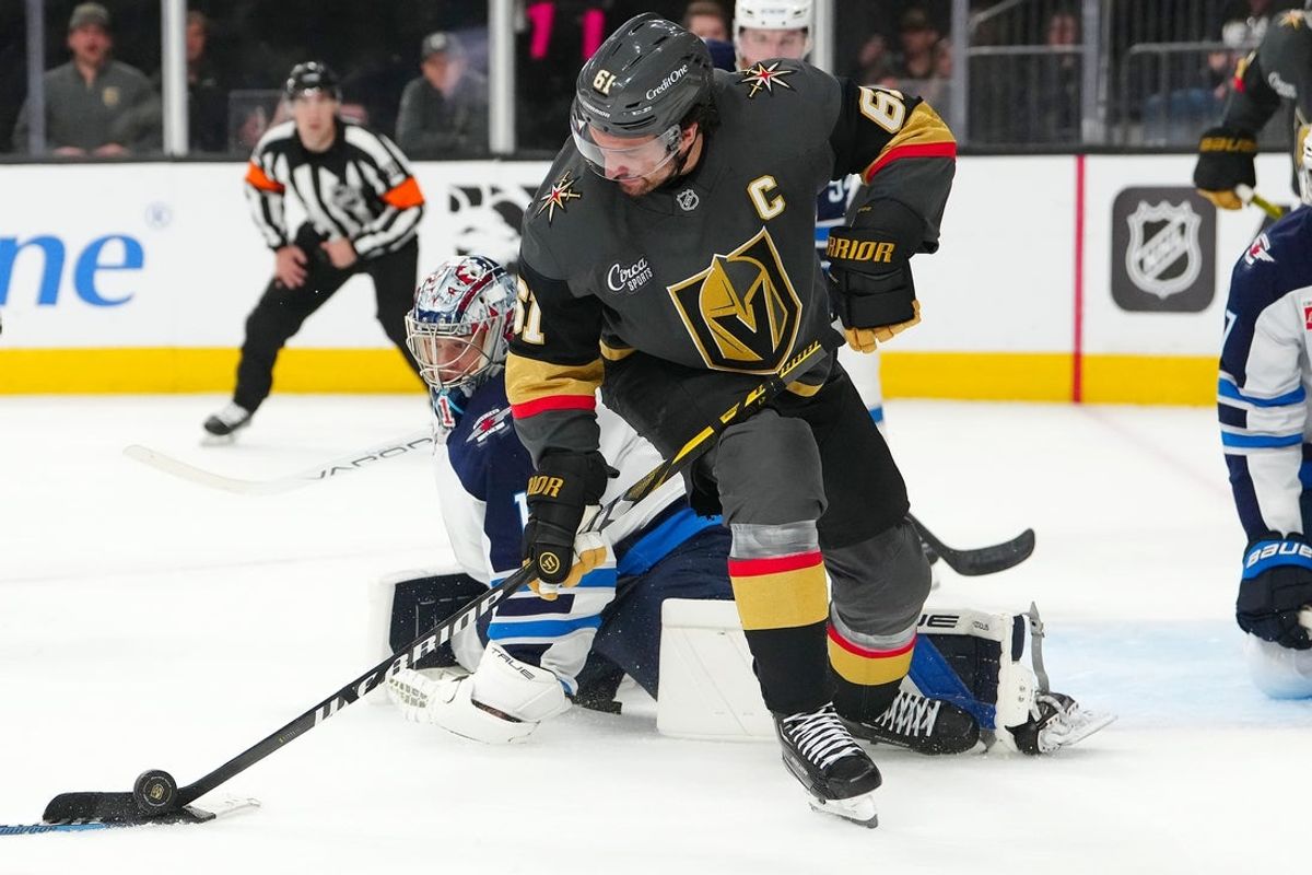 Apr 3, 2025; Las Vegas, Nevada, USA; Vegas Golden Knights right wing Mark Stone (61) controls the puck beside Winnipeg Jets goaltender Eric Comrie (1) during the second period at T-Mobile Arena. Mandatory Credit: Stephen R. Sylvanie-Imagn Images