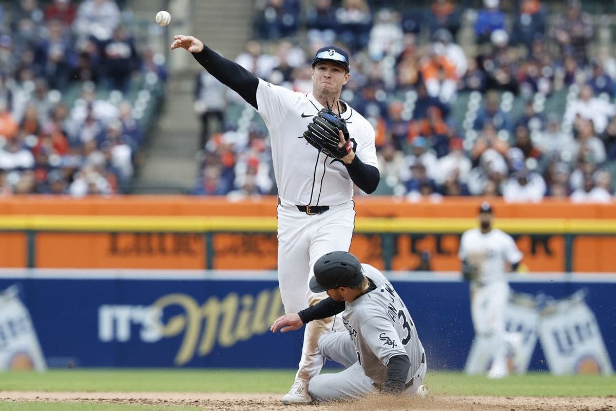 Apr 4, 2025; Detroit, Michigan, USA;  Detroit Tigers second base Colt Keith (33) makes a throw to first as Chicago White Sox outfielder Travis Jankowski (31) slides into second in the ninth inning at Comerica Park. Mandatory Credit: Rick Osentoski-Imagn Images