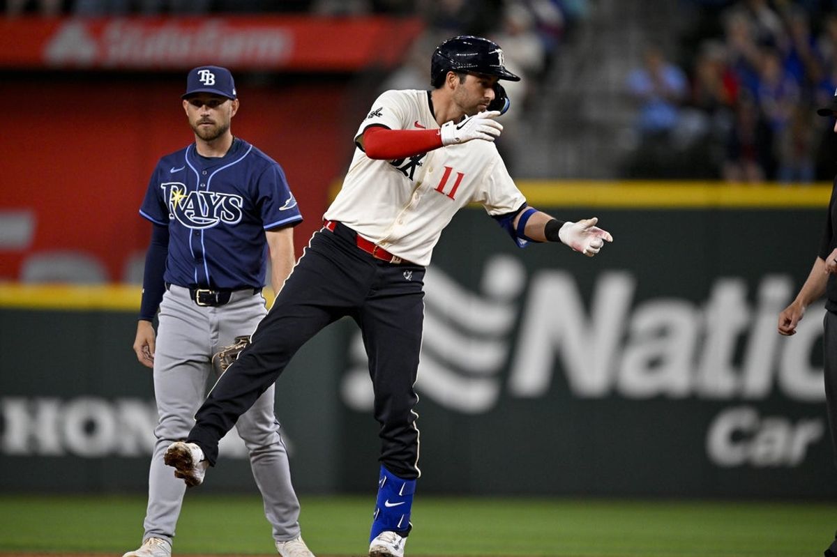 Apr 4, 2025; Arlington, Texas, USA; Texas Rangers catcher Kyle Higashioka (11) hits a double and drives in a run against the Tampa Bay Rays during the third inning at Globe Life Field. Mandatory Credit: Jerome Miron-Imagn Images
