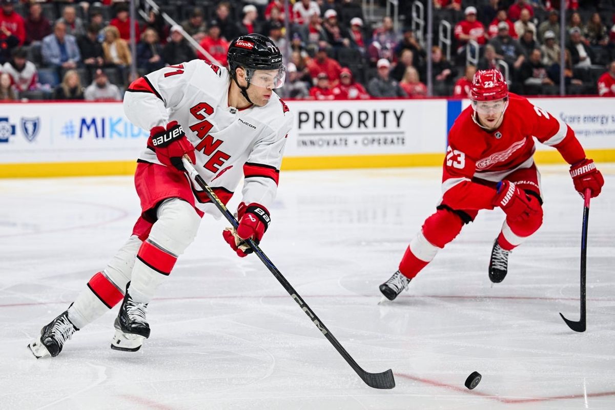 Apr 4, 2025; Detroit, Michigan, USA; Carolina Hurricanes left wing Taylor Hall (71) skates around Detroit Red Wings left wing Lucas Raymond (23) during the game at Little Caesars Arena. Mandatory Credit: Tim Fuller-Imagn Images