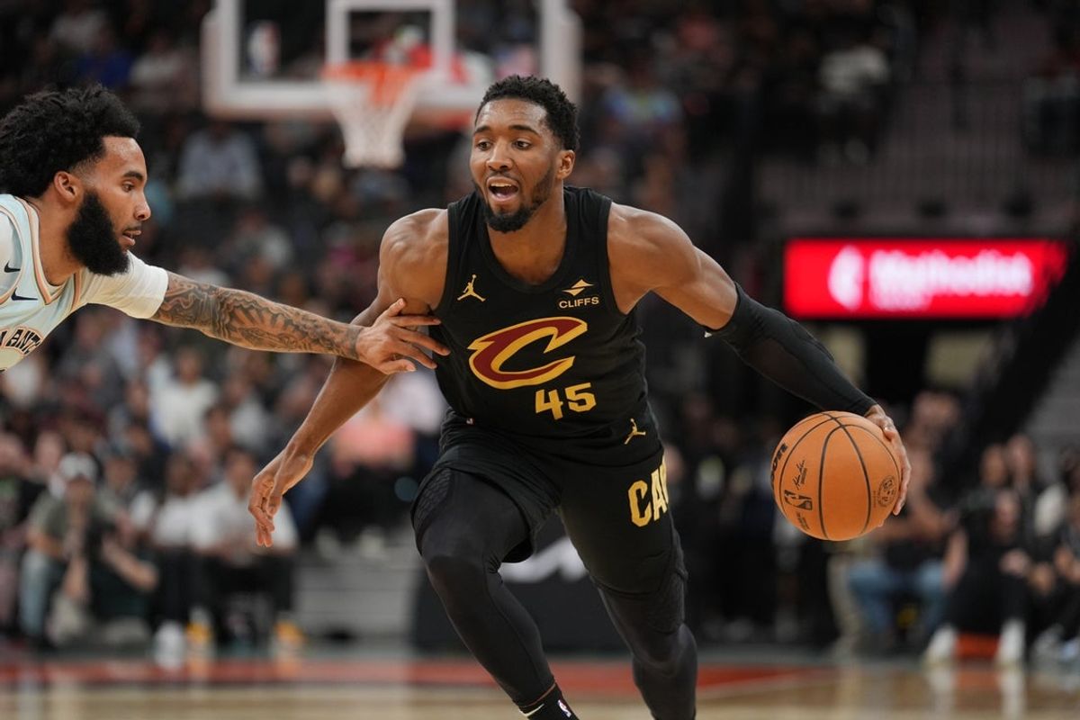 Apr 4, 2025; San Antonio, Texas, USA;  Cleveland Cavaliers guard Donovan Mitchell (45) dribbles against San Antonio Spurs forward Julian Champagnie (30) in the first half at Frost Bank Center. Mandatory Credit: Daniel Dunn-Imagn Images