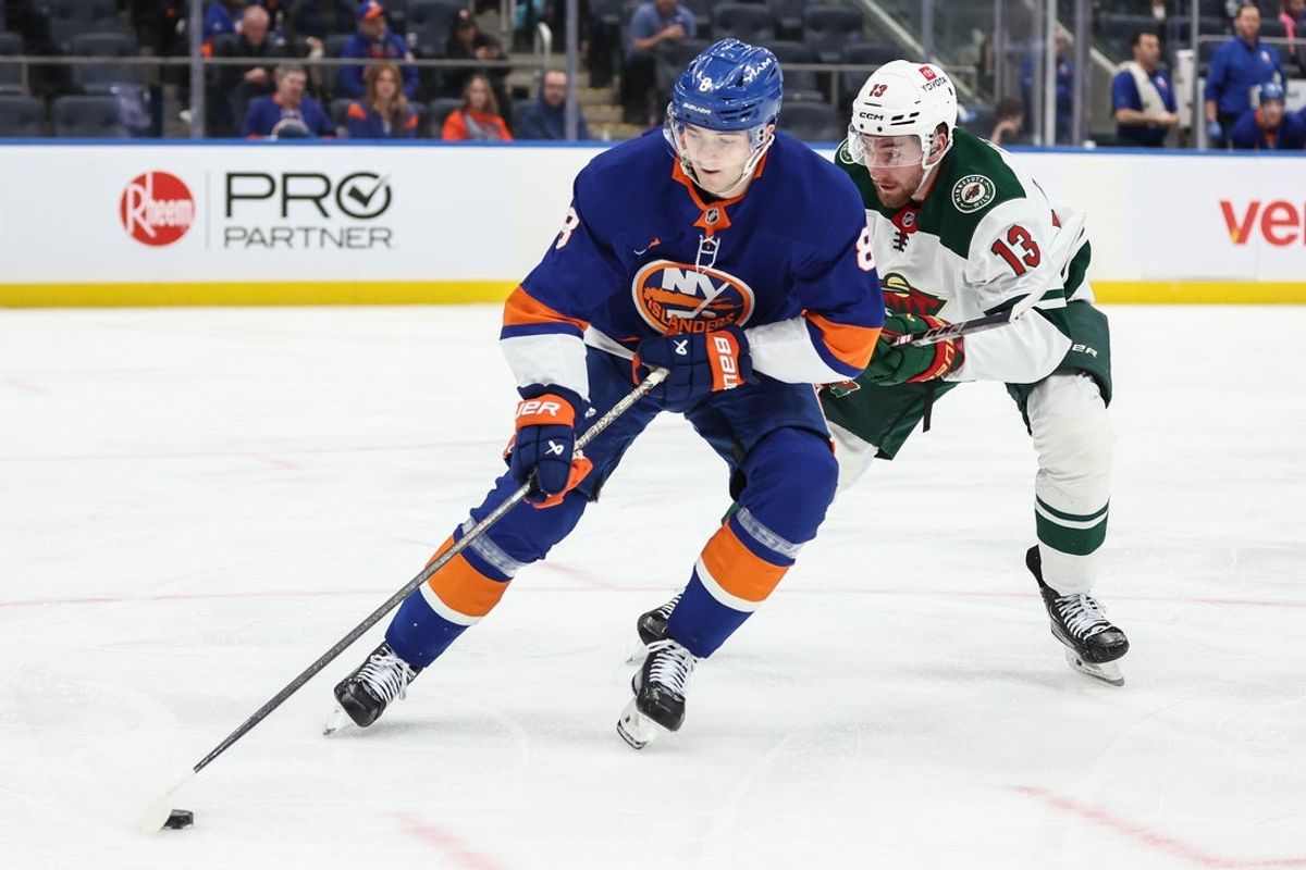 Apr 4, 2025; Elmont, New York, USA;  New York Islanders defenseman Noah Dobson (8) and Minnesota Wild center Yakov Trenin (13) battle for control of the puck in the third period at UBS Arena. Mandatory Credit: Wendell Cruz-Imagn Images