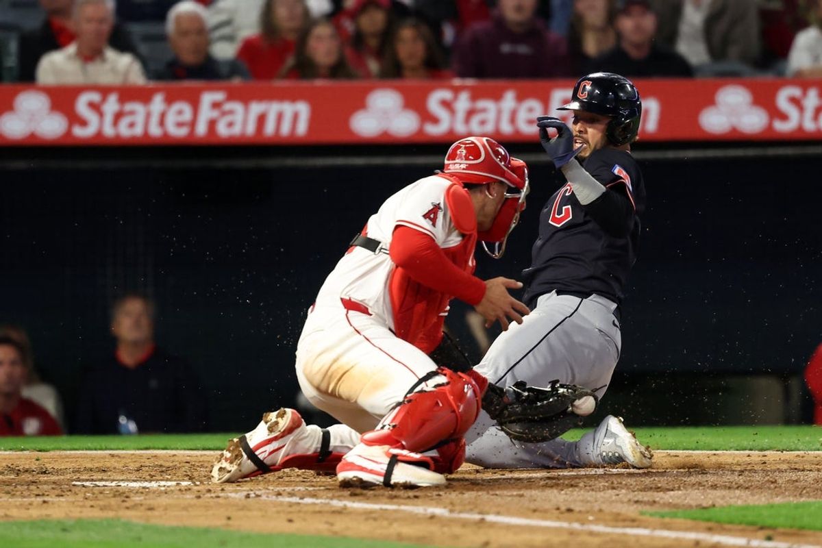 Apr 4, 2025; Anaheim, California, USA;  Cleveland Guardians second baseman Gabriel Arias (13) slides home and scores ahead of a tag from Los Angeles Angels catcher Logan O'Hoppe (14) during the second inning at Angel Stadium. Mandatory Credit: Kiyoshi Mio-Imagn Images