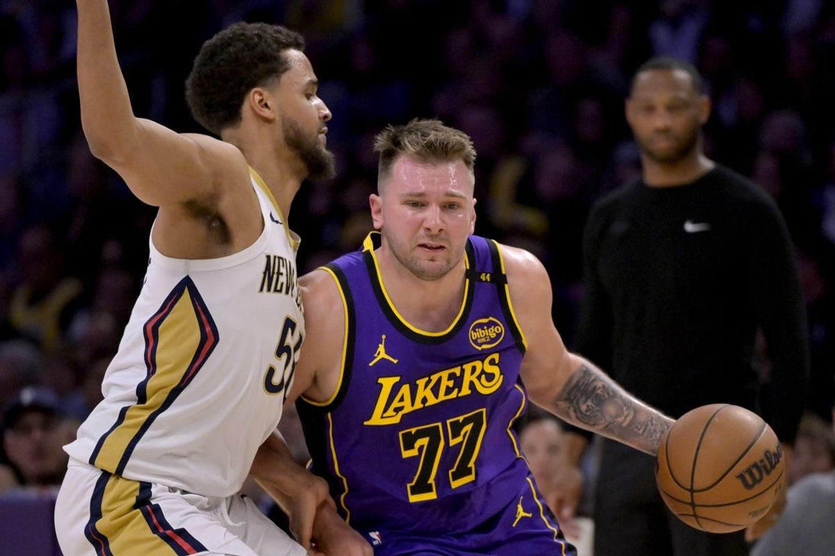 Apr 4, 2025; Los Angeles, California, USA;  Los Angeles Lakers guard Luka Doncic (77) is defended by New Orleans Pelicans forward Jeremiah Robinson-Earl (50) in the first half at Crypto.com Arena. Mandatory Credit: Jayne Kamin-Oncea-Imagn Images