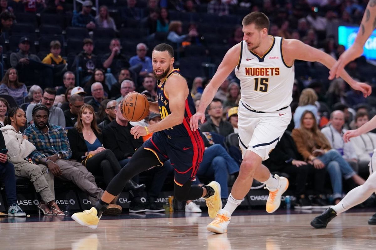 Apr 4, 2025; San Francisco, California, USA;  Golden State Warriors guard Stephen Curry (30) dribbles past Denver Nuggets center Nikola Jokic (15) in the third period at Chase Center. Mandatory Credit: David Gonzales-Imagn Images