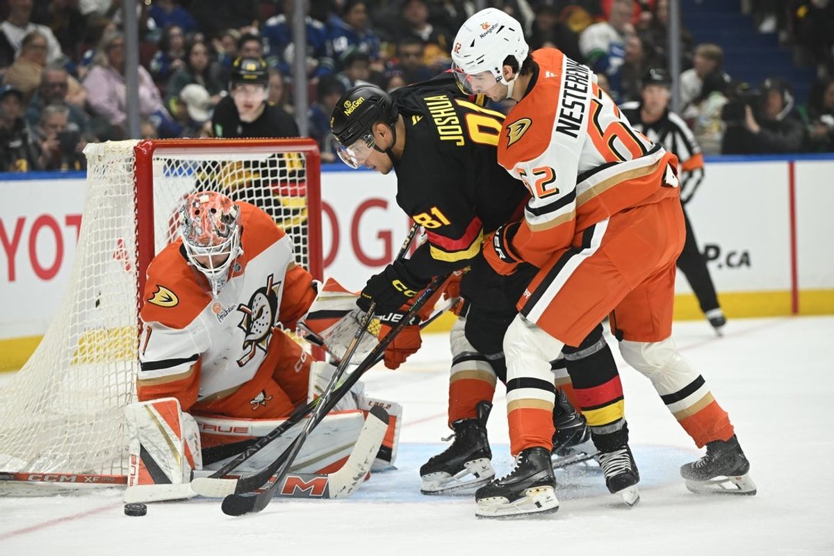 Apr 5, 2025; Vancouver, British Columbia, CAN;  Vancouver Canucks forward Dakota Joshua (81) reaches for the puck against Anaheim Ducks forward Nikita Nesterenko (62) and goaltender Lukas Dostal (1) at Rogers Arena. Mandatory Credit: Anne-Marie Sorvin-Imagn Images