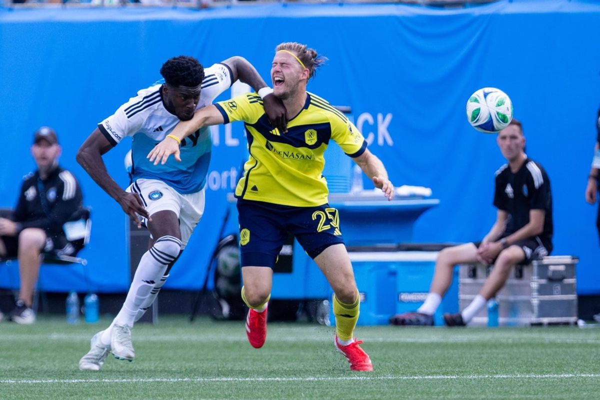 Apr 5, 2025; Charlotte, North Carolina, USA; Charlotte FC forward Patrick Agyemang (33) fouls Nashville SC defender Walker Zimmerman (25) during the second half at Bank of America Stadium. Mandatory Credit: Scott Kinser-Imagn Images