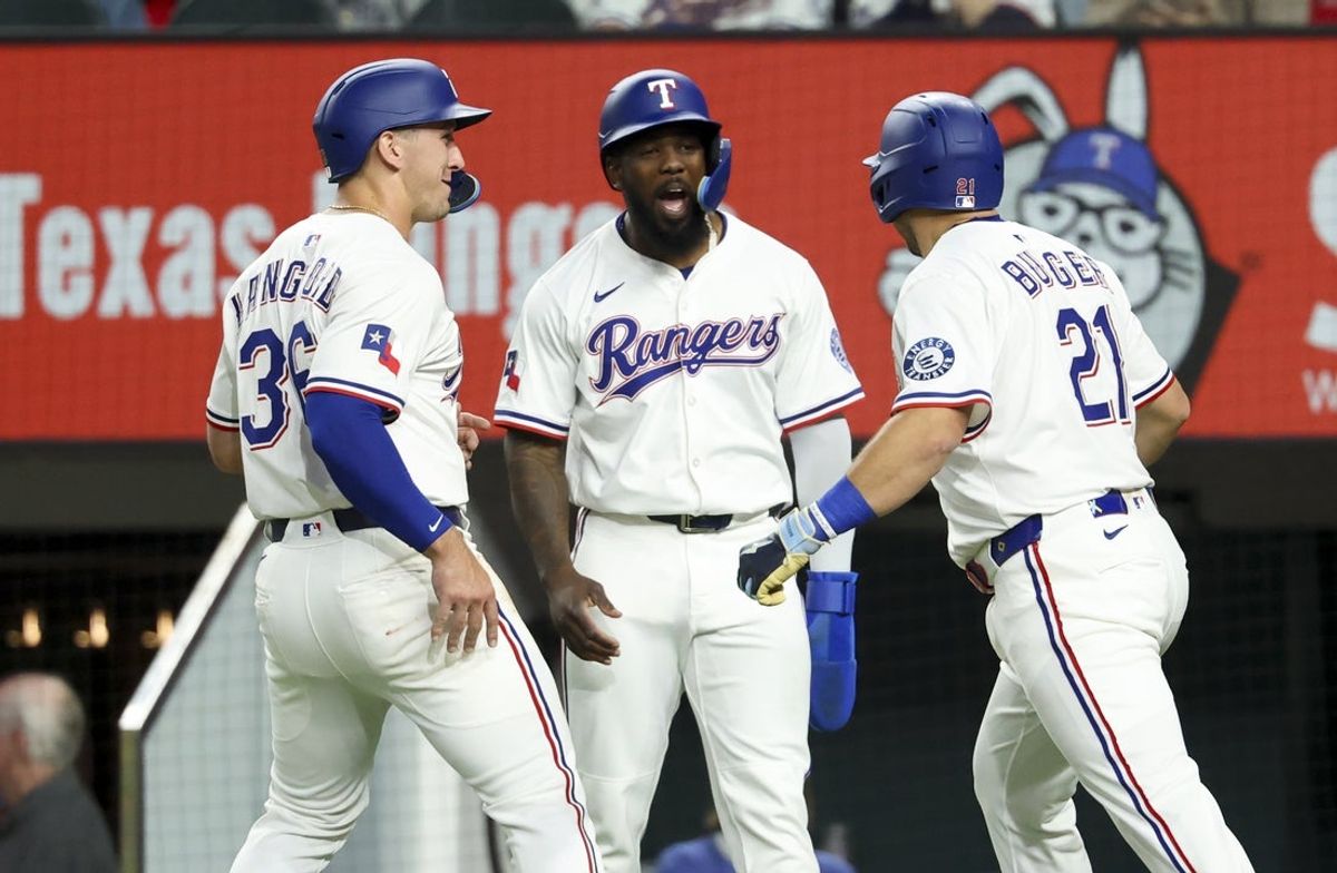 Apr 5, 2025; Arlington, Texas, USA; Texas Rangers first baseman Jake Burger (21) celebrates with Texas Rangers left fielder Wyatt Langford (36) and Texas Rangers right fielder Adolis Garcia (53) after hitting a three-run home run during the first inning against the Tampa Bay Rays at Globe Life Field. Mandatory Credit: Kevin Jairaj-Imagn Images