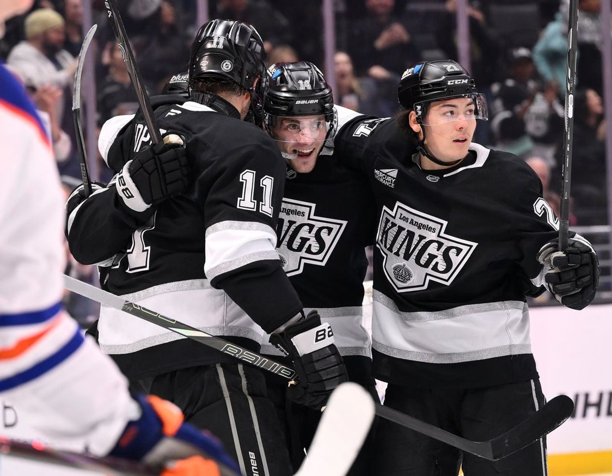 Apr 5, 2025; Los Angeles, California, USA; Los Angeles Kings left wing Kevin Fiala (22) celebrates with teammates Anze Kopitar (11) and  Jordan Spence (21) after scoring during the second period against the Edmonton Oilers at Crypto.com Arena. Mandatory Credit: Robert Hanashiro-Imagn Images