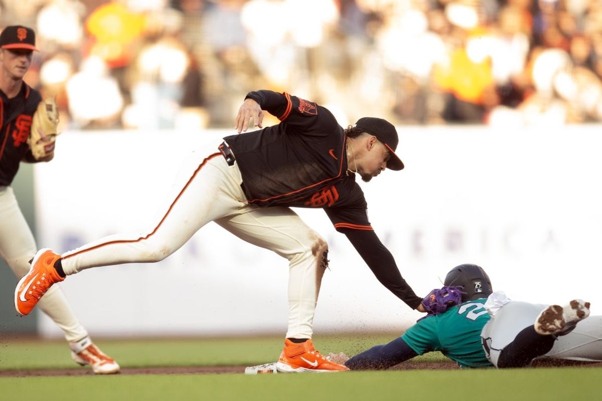 Apr 5, 2025; San Francisco, California, San Francisco Giants shortstop Willy Adames (2) applies the tag to Seattle Mariners third baseman Dylan Moore (25) during an attempt to steal second base in the second inning at Oracle Park. Mandatory Credit: D. Ross Cameron-Imagn Images