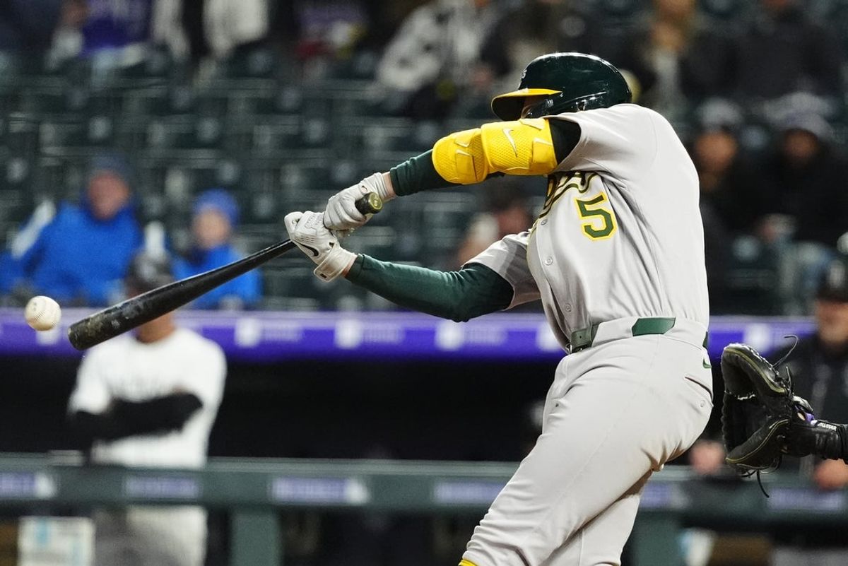 Apr 5, 2025; Denver, Colorado, USA; Athletics shortstop Jacob Wilson (5) RBI doubles in the sixth inning against the Colorado Rockies at Coors Field. Mandatory Credit: Ron Chenoy-Imagn Images