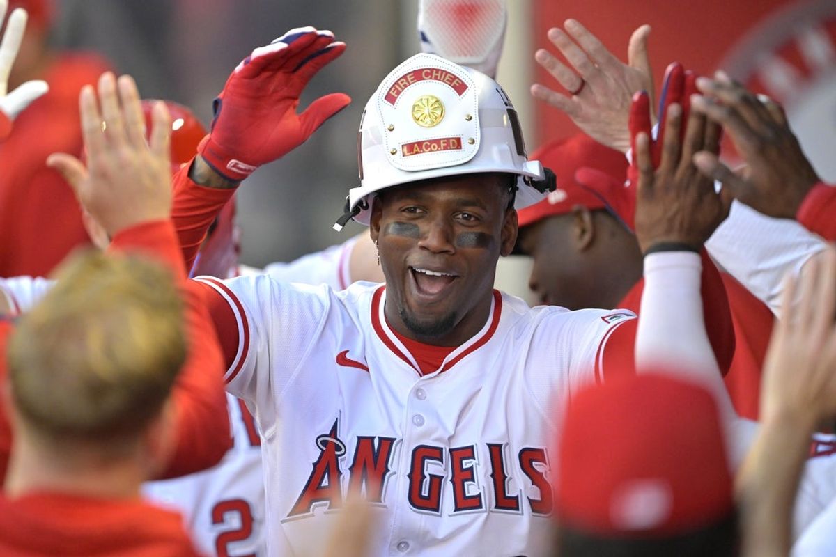 Apr 5, 2025; Anaheim, California, USA;  Los Angeles Angels right fielder Jorge Soler (12) is congratulated in the dugout after hitting a two-run home run scoring center fielder Mike Trout (27) in the first inning against the Cleveland Guardians at Angel Stadium. Mandatory Credit: Jayne Kamin-Oncea-Imagn Images