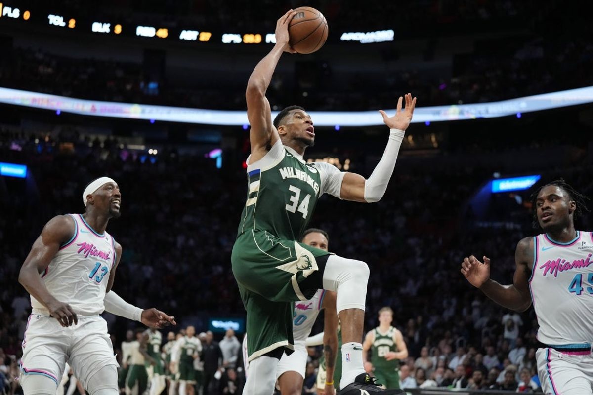 Apr 5, 2025; Miami, Florida, USA;  Milwaukee Bucks forward Giannis Antetokounmpo (34) goes up for a dunk in overtime as Miami Heat center Bam Adebayo (13) follows on the play at Kaseya Center. Mandatory Credit: Jim Rassol-Imagn Images