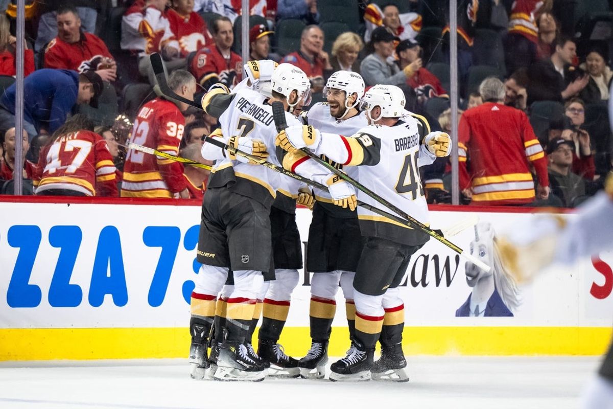 Apr 5, 2025; Calgary, Alberta, CAN; Vegas Golden Knights right wing Reilly Smith (19) celebrates with teammates after scoring the game-winning goal in overtime against the Calgary Flames at Scotiabank Saddledome. Mandatory Credit: Brett Holmes-Imagn Images
