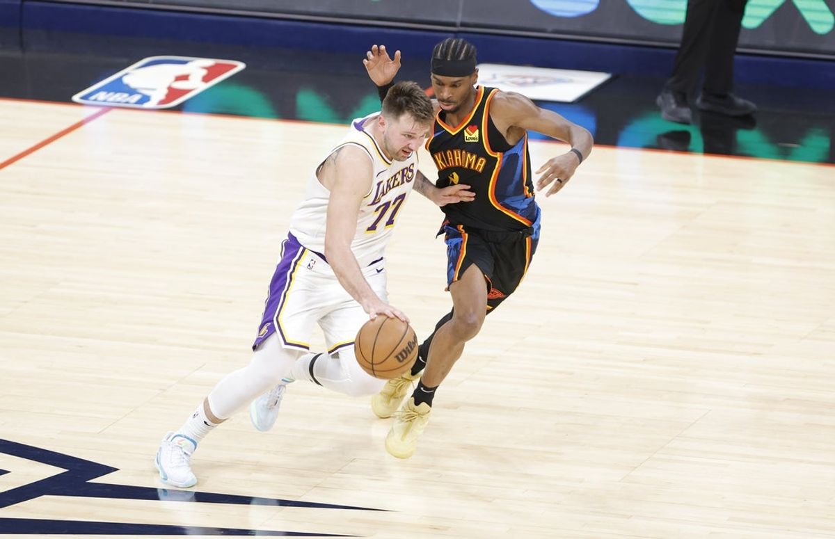 Apr 6, 2025; Oklahoma City, Oklahoma, USA; Los Angeles Lakers guard Luka Doncic (77) drives down the court beside Oklahoma City Thunder guard Shai Gilgeous-Alexander (2) during the second half at Paycom Center. Mandatory Credit: Alonzo Adams-Imagn Images