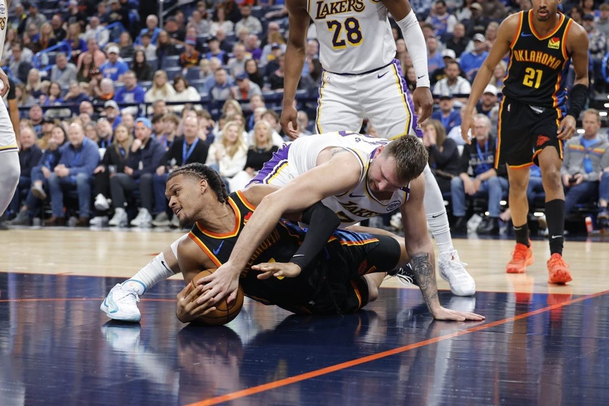 Apr 6, 2025; Oklahoma City, Oklahoma, USA; Oklahoma City Thunder forward Dillon Jones (3) and Los Angeles Lakers guard Luka Doncic (77) fight for a loose ball during the second half at Paycom Center. Mandatory Credit: Alonzo Adams-Imagn Images