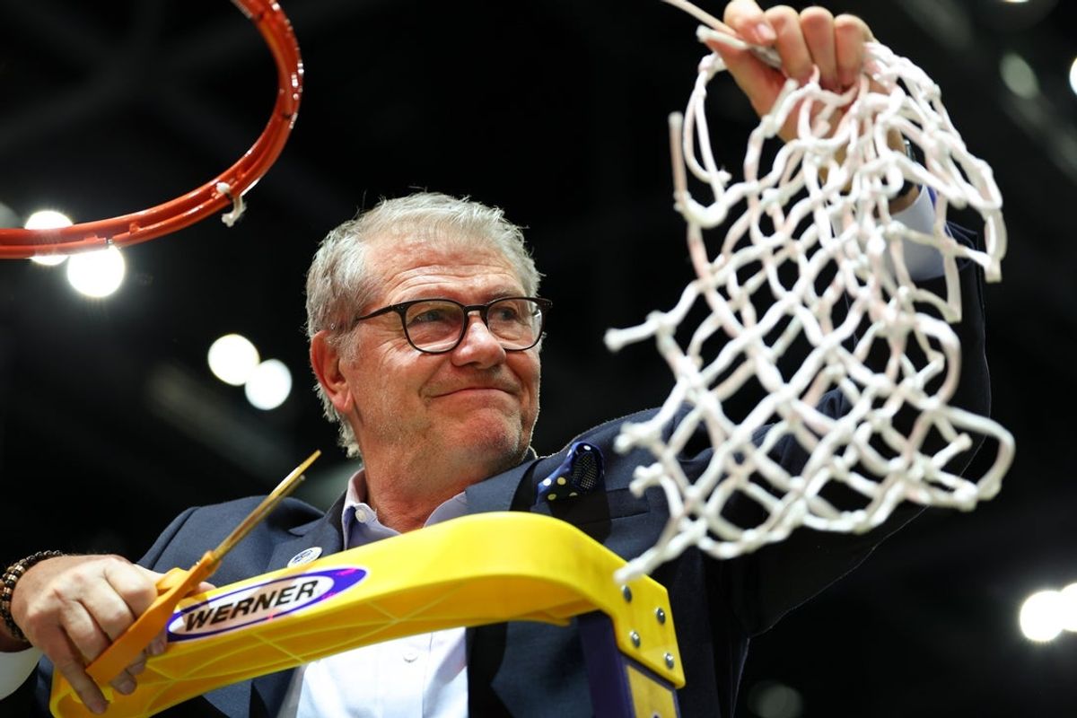 Apr 6, 2025; Tampa, FL, USA; Connecticut Huskies head coach Geno Auriemma cuts off the net after the national championship of the women's 2025 NCAA tournament against the South Carolina Gamecocks at Amalie Arena. Mandatory Credit: Nathan Ray Seebeck-Imagn Images