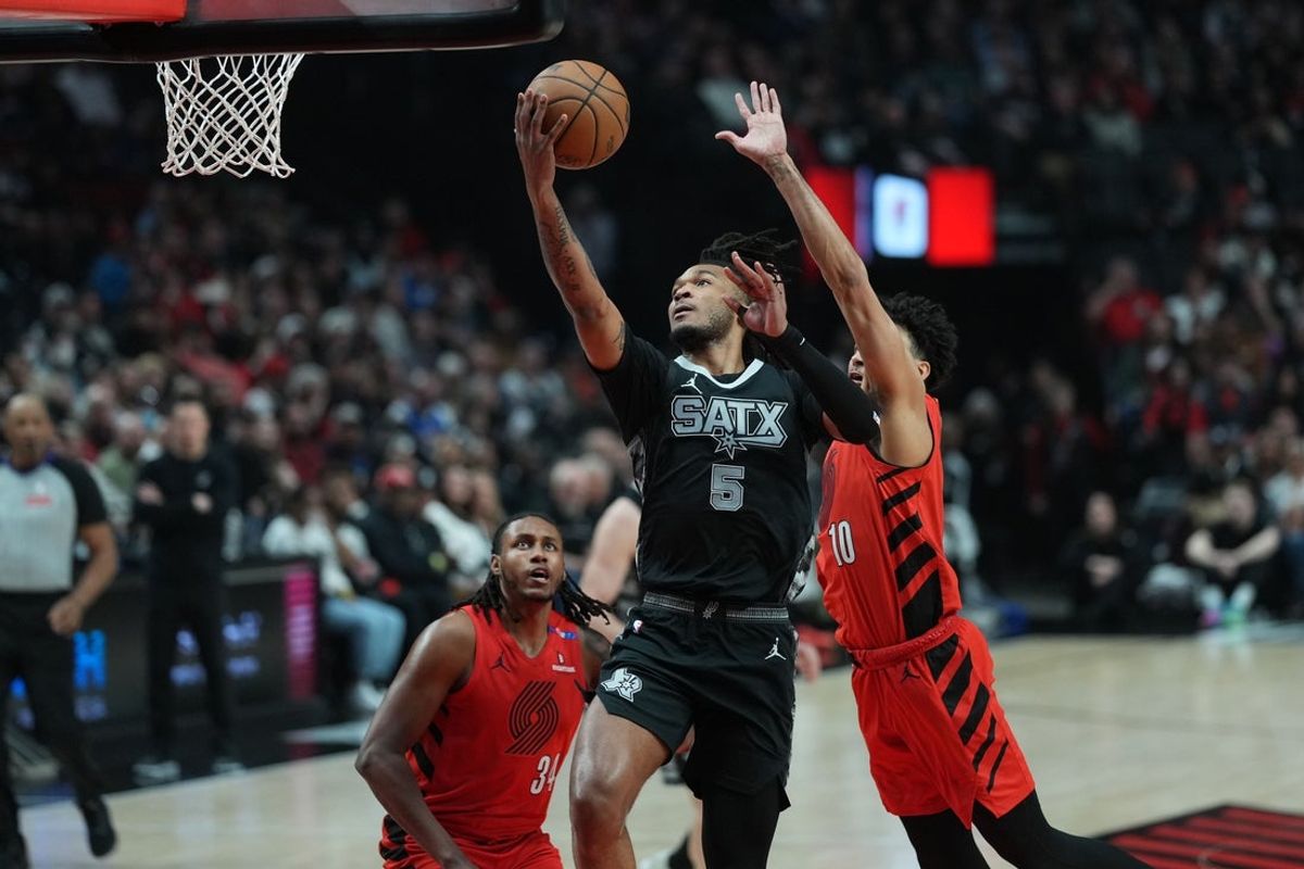 Apr 6, 2025; Portland, Oregon, USA; San Antonio Spurs guard Stephon Castle (5) lays up a shot against Portland Trail Blazers forward Justin Minaya (10) during the first half at Moda Center. Mandatory Credit: Soobum Im-Imagn Images