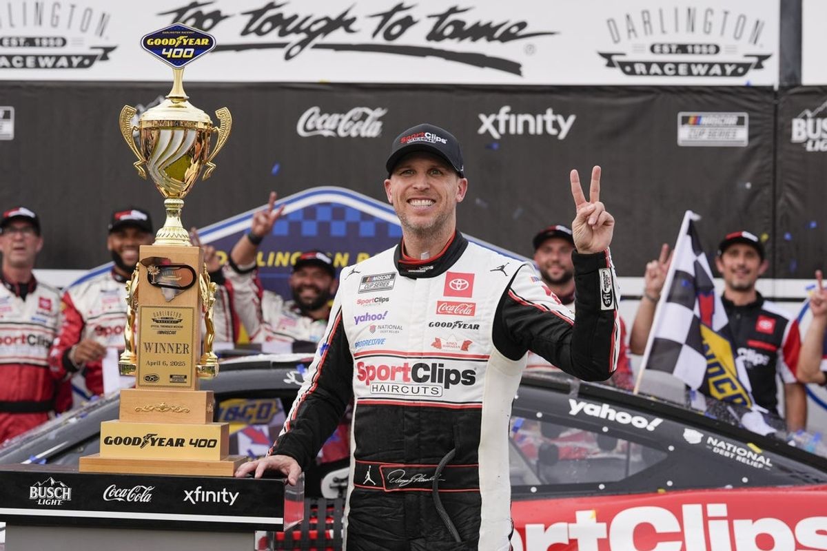 Apr 6, 2025; Darlington, South Carolina, USA; NASCAR Cup Series driver Denny Hamlin (11) and his crew celebrate the win during the Goodyear 400 at Darlington Raceway. Mandatory Credit: Jim Dedmon-Imagn Images