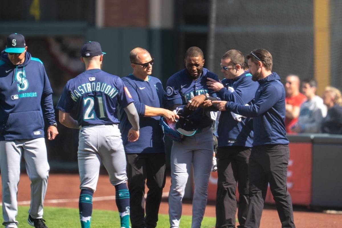 Apr 6, 2025; San Francisco, California, USA; Seattle Mariners right fielder Victor Robles (10) is injured during the play against the San Francisco Giants during the ninth inning attended medical personal at Oracle Park. Mandatory Credit: Neville E. Guard-Imagn Images