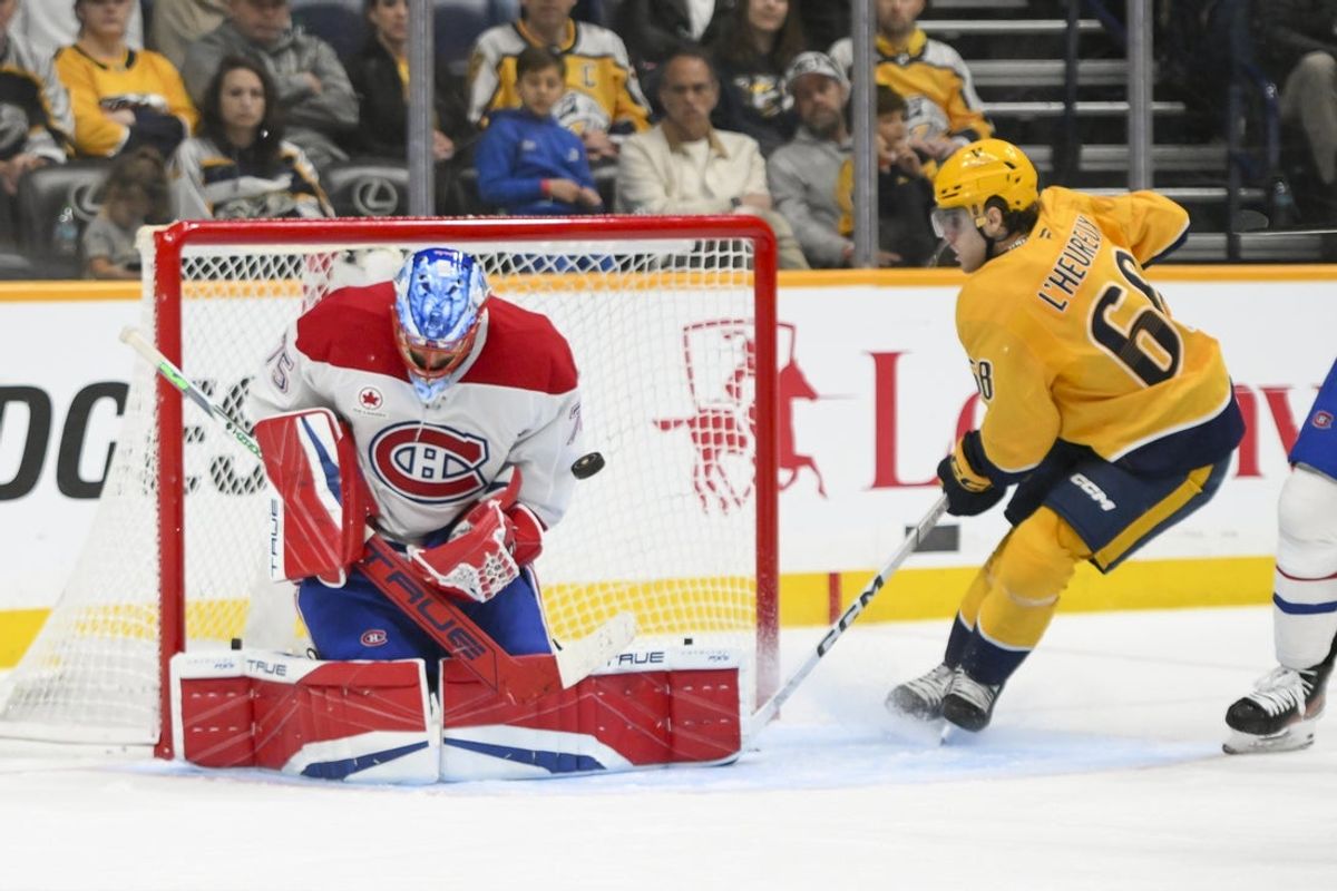 Apr 6, 2025; Nashville, Tennessee, USA; Montreal Canadiens goaltender Jakub Dobes (75) blocks the shot of Nashville Predators left wing Zachary L'Heureux (68) during the second period at Bridgestone Arena. Mandatory Credit: Steve Roberts-Imagn Images