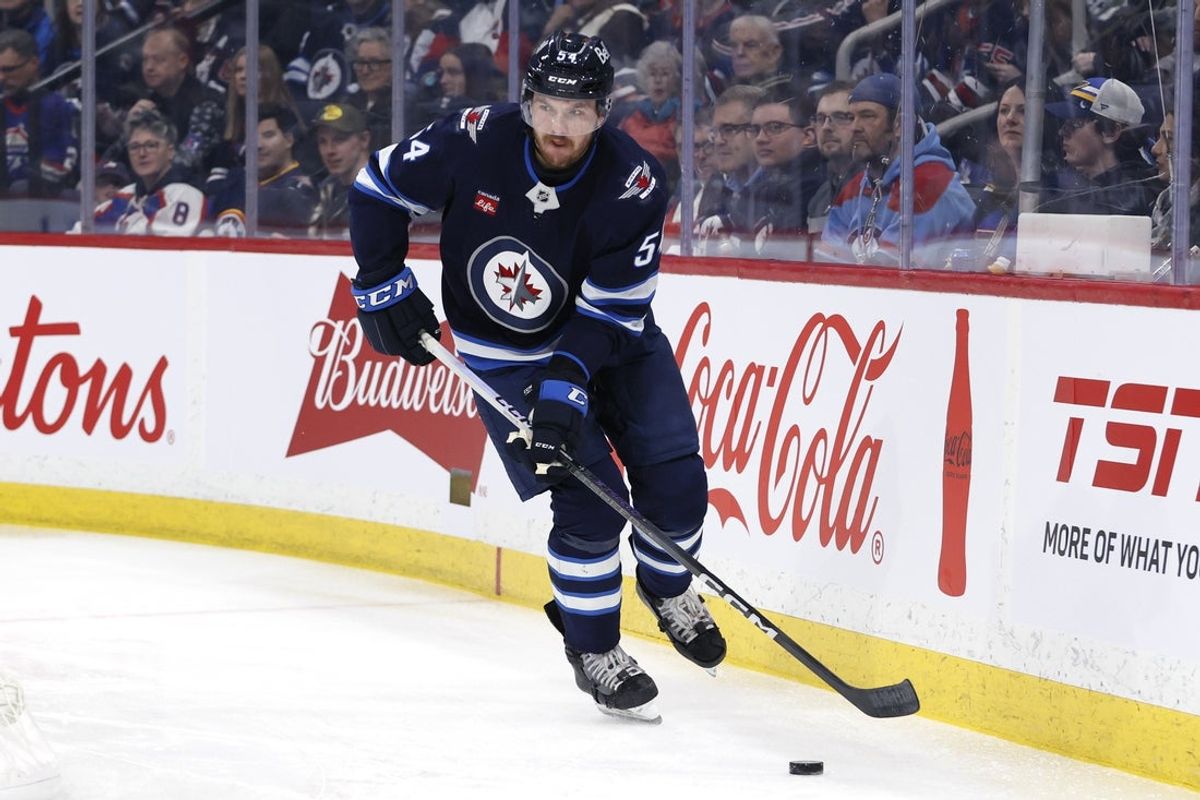 Apr 7, 2025; Winnipeg, Manitoba, CAN; Winnipeg Jets defenseman Dylan Samberg (54) skates up the ice against the St. Louis Blues in the first period at Canada Life Centre. Mandatory Credit: James Carey Lauder-Imagn Images