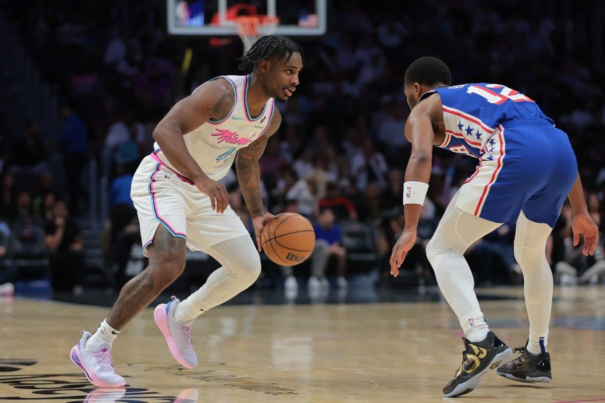 Apr 7, 2025; Miami, Florida, USA; Miami Heat guard Davion Mitchell (45) dribbles the basketball as Philadelphia 76ers guard Jared Butler (12) defends during the first quarter at Kaseya Center. Mandatory Credit: Sam Navarro-Imagn Images