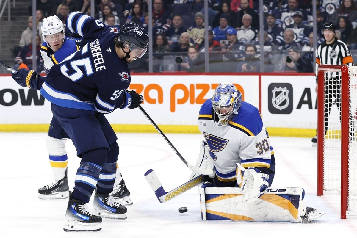 Apr 7, 2025; Winnipeg, Manitoba, CAN; St. Louis Blues goaltender Joel Hofer (30) blocks a shot by Winnipeg Jets center Mark Scheifele (55) in the second period at Canada Life Centre. Mandatory Credit: James Carey Lauder-Imagn Images