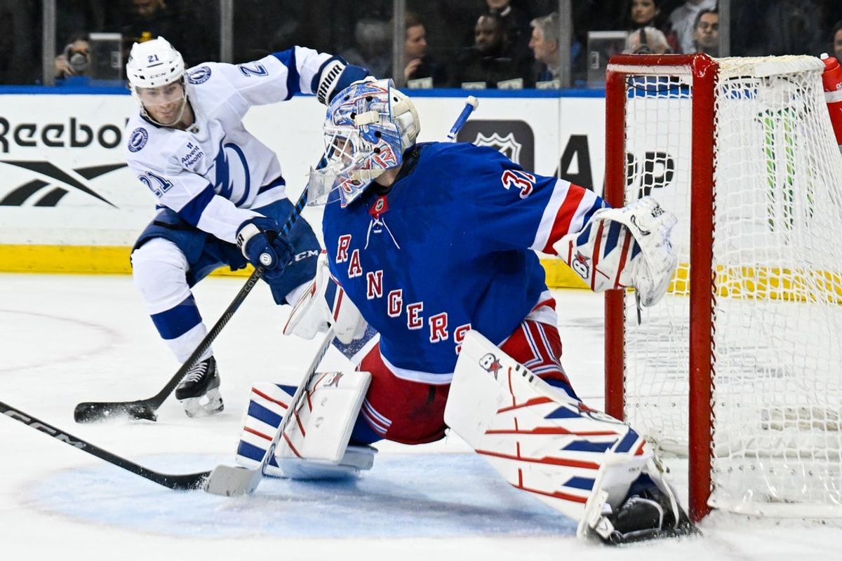 Apr 7, 2025; New York, New York, USA;  Tampa Bay Lightning center Brayden Point (21) takes a shot and scores his second goal of the game against New York Rangers goaltender Igor Shesterkin (31) during the third period at Madison Square Garden. Mandatory Credit: Dennis Schneidler-Imagn Images
