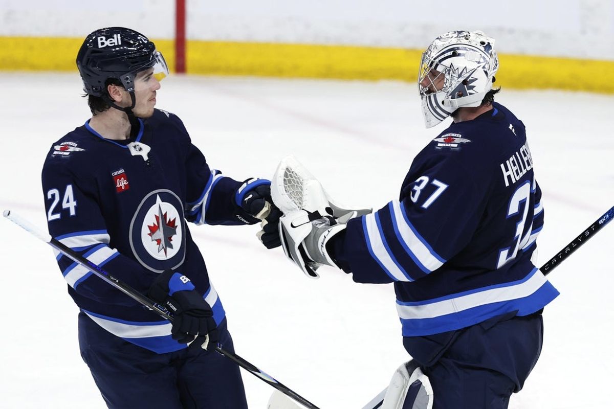 Apr 7, 2025; Winnipeg, Manitoba, CAN; Winnipeg Jets defenseman Haydn Fleury (24) and Winnipeg Jets goaltender Connor Hellebuyck (37) celebrate their victory over the St. Louis Blues at Canada Life Centre. Mandatory Credit: James Carey Lauder-Imagn Images