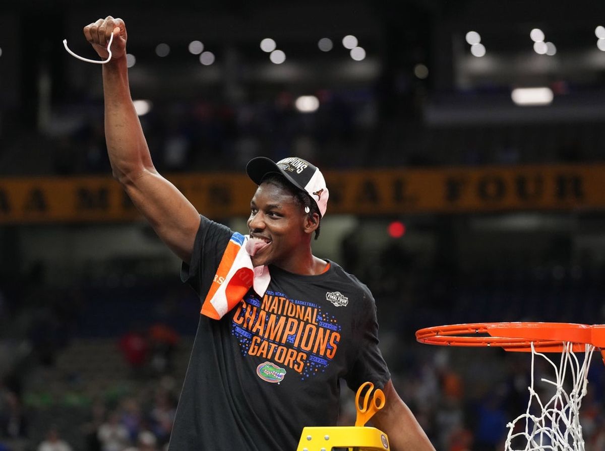 Apr 7, 2025; San Antonio, TX, USA; Florida Gators center Rueben Chinyelu (9) cuts down a pice of the net after defeating the Houston Cougars in the national championship game of the Final Four of the 2025 NCAA Tournament at the Alamodome. Mandatory Credit: Robert Deutsch-Imagn Images