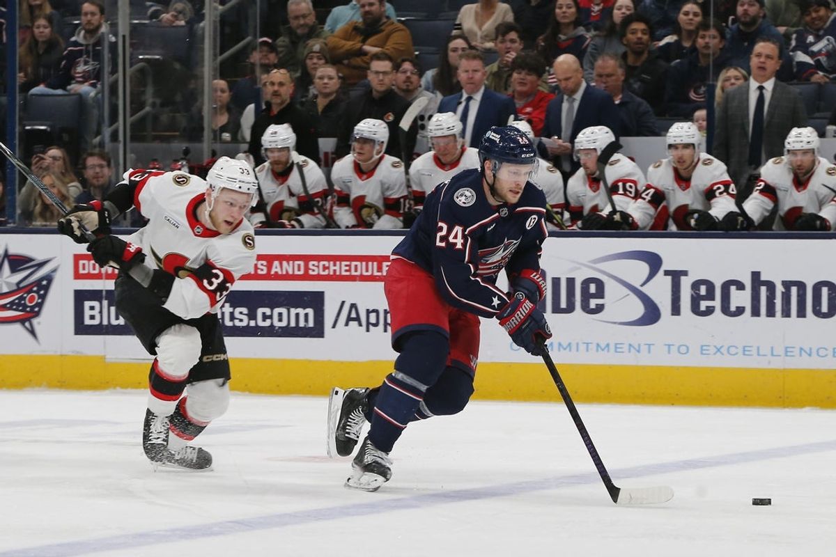 Apr 8, 2025; Columbus, Ohio, USA; Columbus Blue Jackets center Mathieu Olivier (24) skates with the puck asOttawa Senators defenseman Nikolas Matinpalo (33) trails the play during the first period at Nationwide Arena. Mandatory Credit: Russell LaBounty-Imagn Images