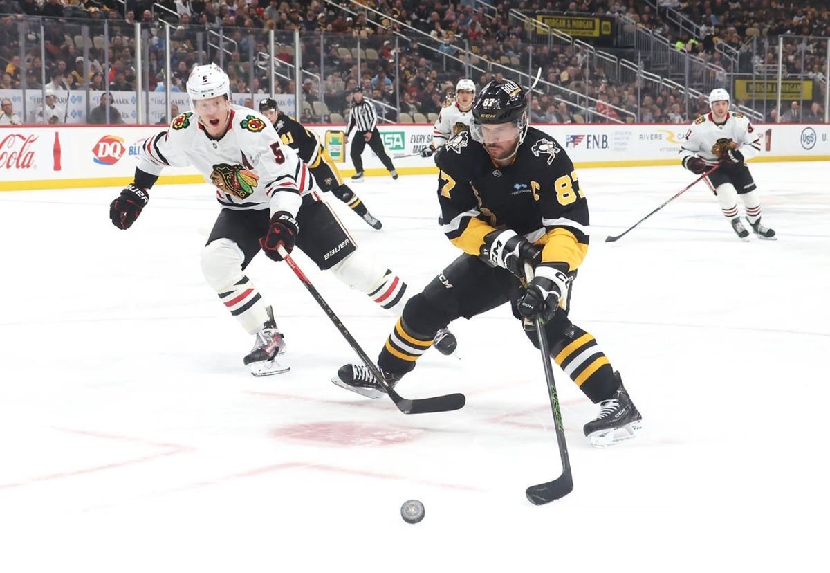 Apr 8, 2025; Pittsburgh, Pennsylvania, USA;  Pittsburgh Penguins center Sidney Crosby (87) chases the puck as Chicago Blackhawks defenseman Connor Murphy (5) defends during the first period at PPG Paints Arena. Mandatory Credit: Charles LeClaire-Imagn Images
