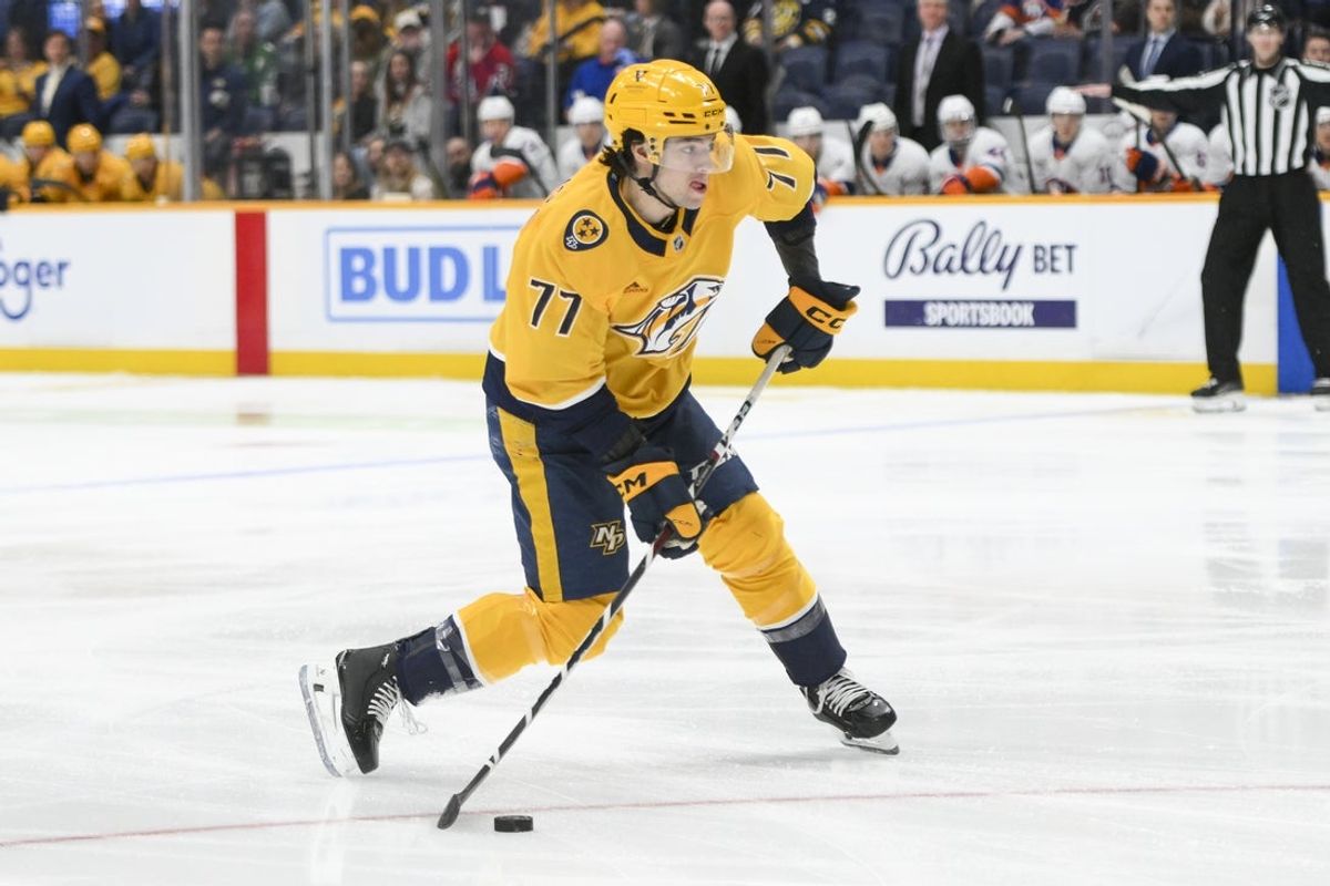 Apr 8, 2025; Nashville, Tennessee, USA;  Nashville Predators right wing Luke Evangelista (77) takes a shot on goal against the New York Islanders during the first period at Bridgestone Arena. Mandatory Credit: Steve Roberts-Imagn Images