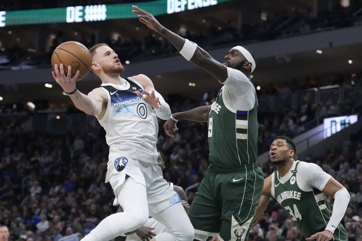 Apr 8, 2025; Milwaukee, Wisconsin, USA; Milwaukee Bucks guard Damian Lillard (0) drives to the basket against Milwaukee Bucks forward Bobby Portis (9) in the first half at Fiserv Forum. Mandatory Credit: Michael McLoone-Imagn Images