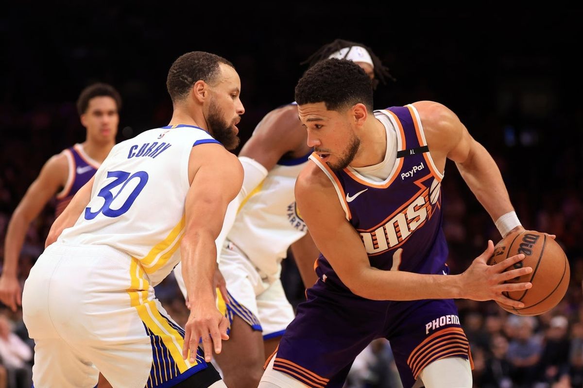 Apr 8, 2025; Phoenix, Arizona, USA; Phoenix Suns guard Devin Booker (1) attempts to drive to the basket against Golden State Warriors guard Stephen Curry (30) during the second half at Footprint Center. Mandatory Credit: Mark J. Rebilas-Imagn Images
