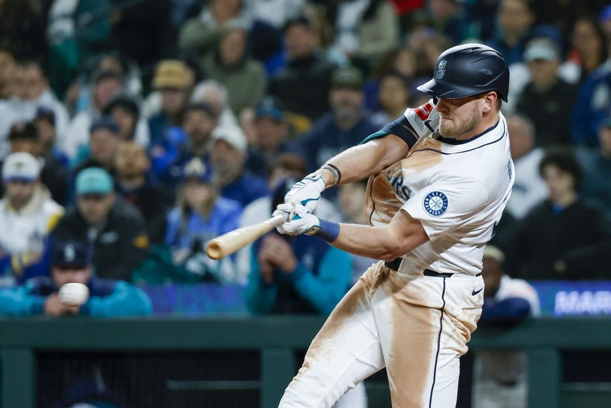 Apr 8, 2025; Seattle, Washington, USA; Seattle Mariners right fielder Luke Raley (20) hits an RBI-infield single against the Houston Astros during the seventh inning at T-Mobile Park. Mandatory Credit: Joe Nicholson-Imagn Images